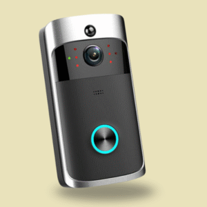 A close-up studio shot of a black smart video doorbell with silver metallic edges, floating slightly above the surface. It features a camera lens and four red indicator dots in the center, and a large round button at the bottom with a thin glowing blue ring. The background is solid light tan.