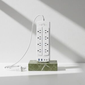 White power strip with USB ports placed on a green stand, showing multiple plugged-in devices.