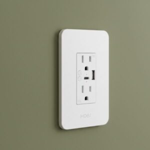 A white smart plug with USB ports is installed on an olive green wall, viewed from a 45-degree angle, highlighting its slim profile against the wall.
