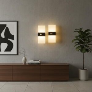 Two rectangular wall sconces with yellow light installed on a grey wall above a wooden cabinet with a framed poster and a houseplant in a modern living room.