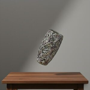 Abstract wire mesh vase floating at a 45-degree angle above a dark wooden table against a plain grey background.