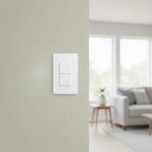 A white two-gang smart switch is installed on a light olive green wall in a blurred modern living room interior.