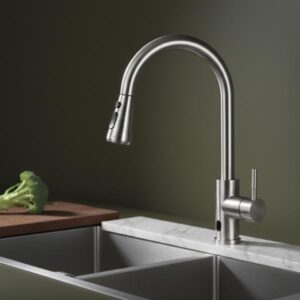 Silver pull-down kitchen faucet installed in a stainless steel sink next to a wooden cutting board with a piece of broccoli.