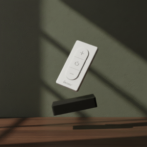 A white remote control and a rectangular black hub are floating over a dark wood surface, photographed against a dark green backdrop with contrasting shadows.